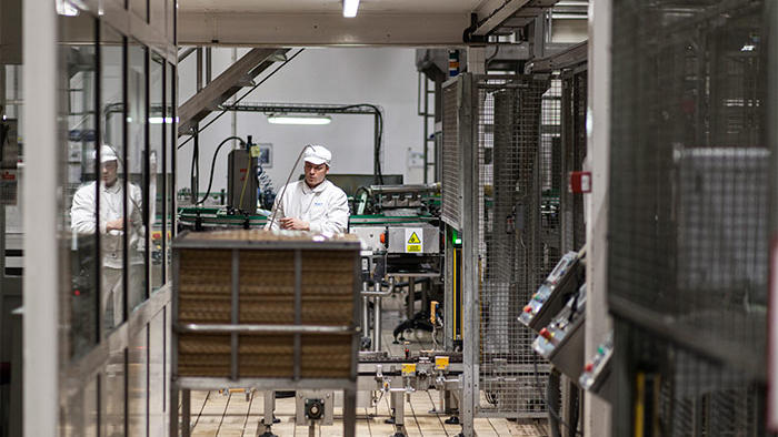 Un dipendente al lavoro nella fabbrica Hero, illuminata con le soluzioni a LED a risparmio energetico per l'industria alimentare di Philips