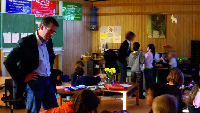 Un insegnante aiuta gli alunni della scuola In der Alten Forst, illuminata con le soluzioni per le scuole di Philips
