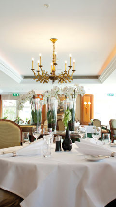 Due persone sedute a un tavolo del ristorante La Rive, illuminato con le soluzioni per hotel, ristoranti e bar di Philips