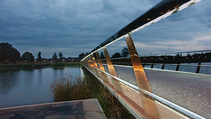 Il ponte nell'High Tech Campus inizia a illuminarsi al calare del sole 