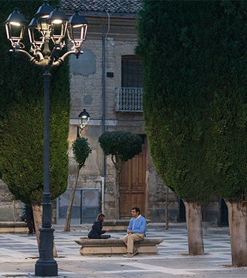 Uomo e bambino che giocano a carte in una strada di Palencia illuminata da Philips Lighting