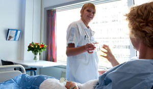Un'infermiera offre un bicchiere d'acqua a un paziente