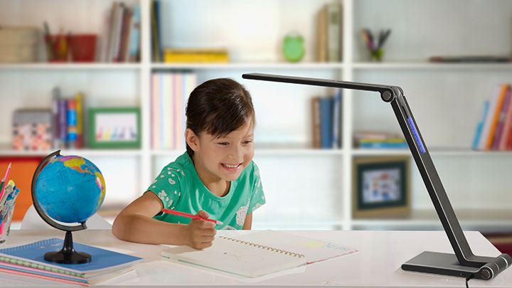 Ragazza che studia sotto una una lampada da scrivania LED Philips