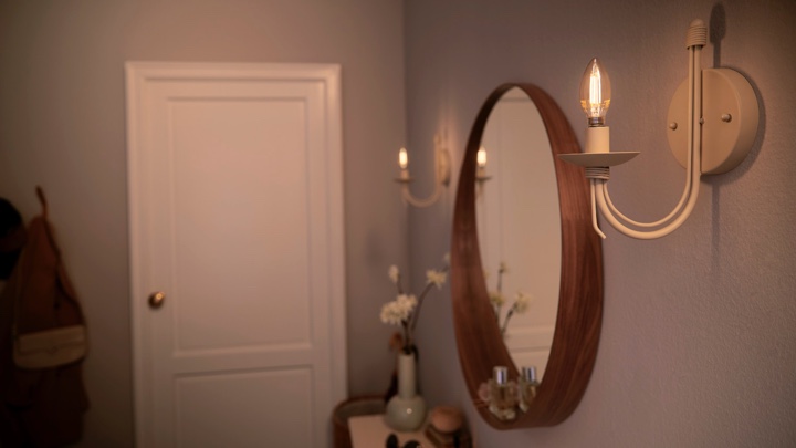 Lampade a candela a i lati di uno specchio in corridoio