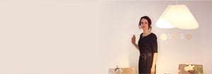 Donna che regola l'illuminazione LED ad alta potenza da incasso tramite un elegante dimmer montato a parete, migliorando l'atmosfera e l'efficienza energetica di un soggiorno moderno.