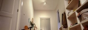 "Ingresso luminoso con luci a LED da incasso che illuminano scaffali, giocattoli e una bicicletta per bambini."