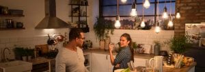 "Cucina moderna con lampadari a LED in stile vintage che illuminano due donne che cenano, creando un'atmosfera calda e invitante."