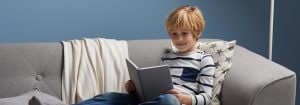 "Bambini che leggono sotto una soffusa luce LED, che crea un'illuminazione confortevole per le storie serali e favorisce sane abitudini del sonno in un ambiente accogliente come la camera da letto."