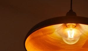 "Lampadina a filamento LED in stile vintage in lampada a sospensione, che emette una calda luce dorata, creando un'illuminazione nostalgica a risparmio energetico per un'accogliente atmosfera domestica."