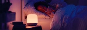 "Luce notturna a LED intelligente che emette una luce calda e soffusa mentre il bambino dorme pacificamente, offrendo un'illuminazione personalizzabile prima di andare a dormire, per un ambiente di sonno ottimale."