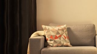 Accogliente soggiorno con moderna lampada da tavolo LED, che illumina il divanetto grigio e crea un'atmosfera calda per il relax domestico.